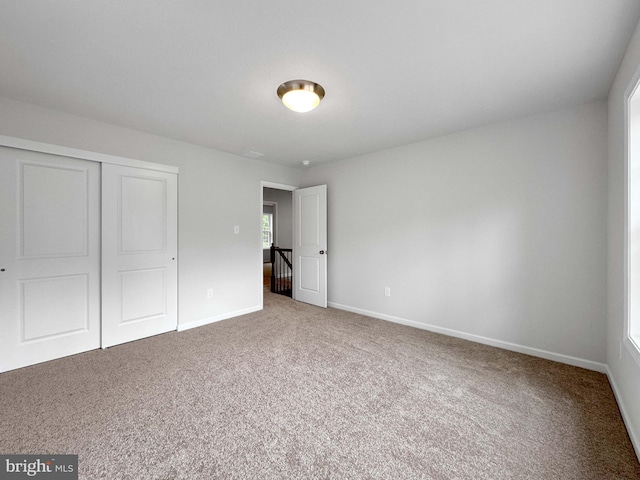 unfurnished bedroom with carpet floors and a closet