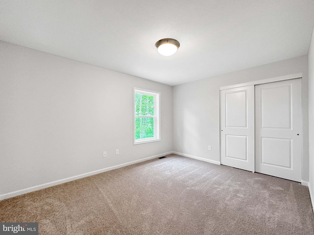 unfurnished bedroom with carpet and a closet