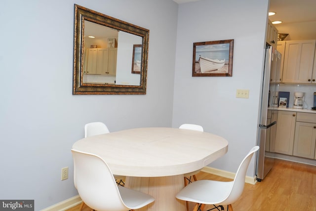 dining space with light wood finished floors and baseboards