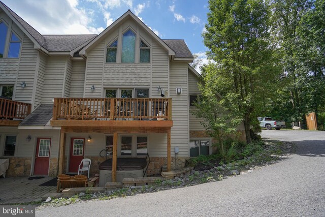 rear view of property with roof with shingles and a wooden deck