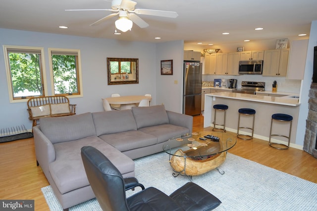 living room with ceiling fan, light wood-style flooring, and recessed lighting