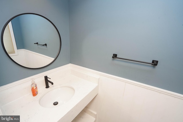 bathroom with a wainscoted wall and a sink