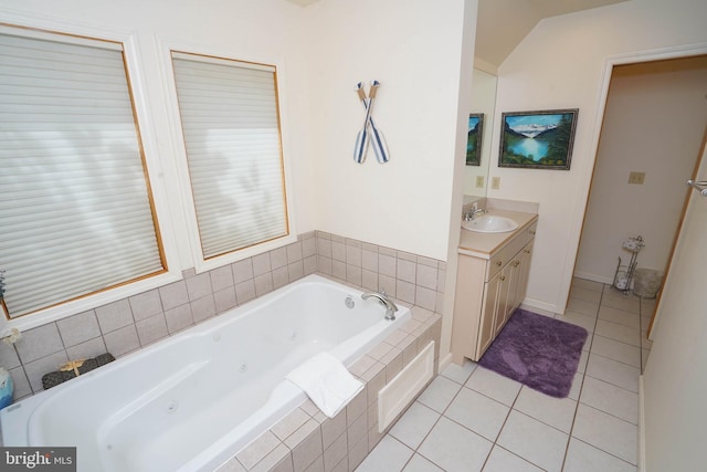 bathroom with a jetted tub, tile patterned flooring, vaulted ceiling, and vanity