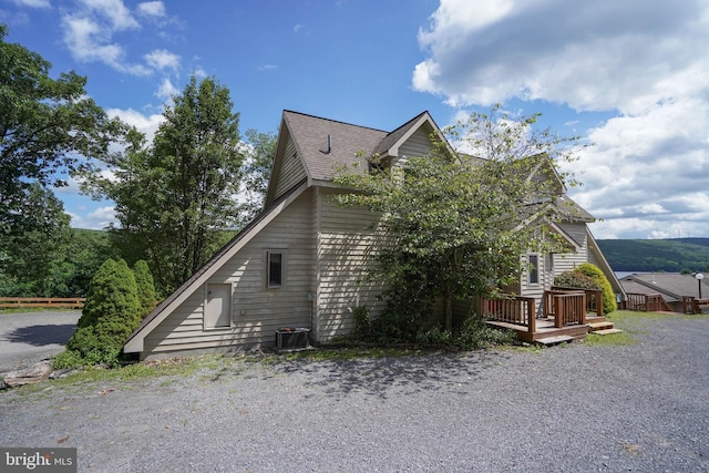 view of home's exterior featuring central air condition unit and a wooden deck