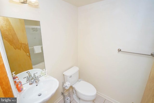 bathroom featuring baseboards, a sink, toilet, and tile patterned floors