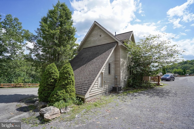 view of side of home with roof with shingles