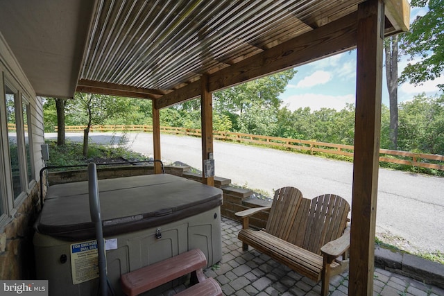 view of patio featuring fence and a hot tub