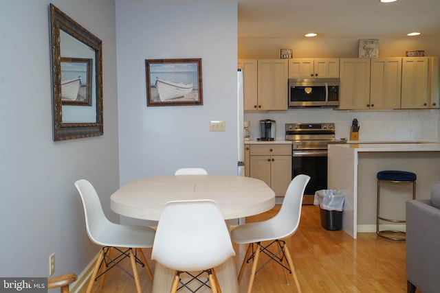 dining space featuring light wood-style flooring, baseboards, and recessed lighting