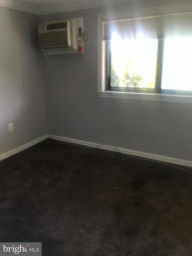 carpeted spare room with an AC wall unit