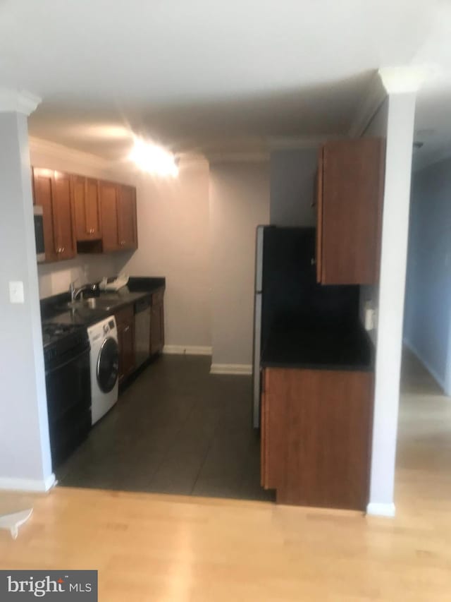 kitchen with sink, washer / dryer, and light wood-type flooring