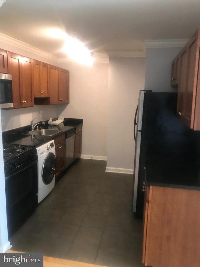 kitchen with sink, dark tile flooring, crown molding, stainless steel appliances, and washer / clothes dryer