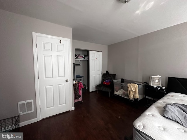 bedroom with dark hardwood / wood-style floors and a closet
