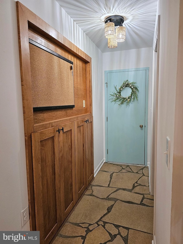 entryway featuring a notable chandelier and light colored carpet