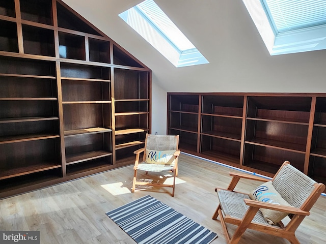 unfurnished room featuring a skylight, a healthy amount of sunlight, and light hardwood / wood-style flooring