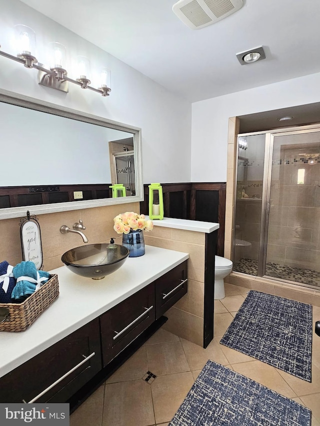 bathroom featuring vanity, tile flooring, toilet, and walk in shower