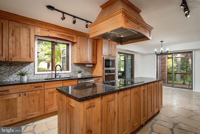 kitchen featuring sink, stainless steel appliances, premium range hood, a chandelier, and tasteful backsplash