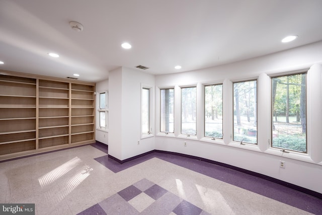 spare room featuring light carpet and a wealth of natural light