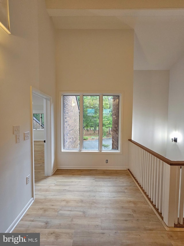 unfurnished room featuring high vaulted ceiling and light hardwood / wood-style flooring