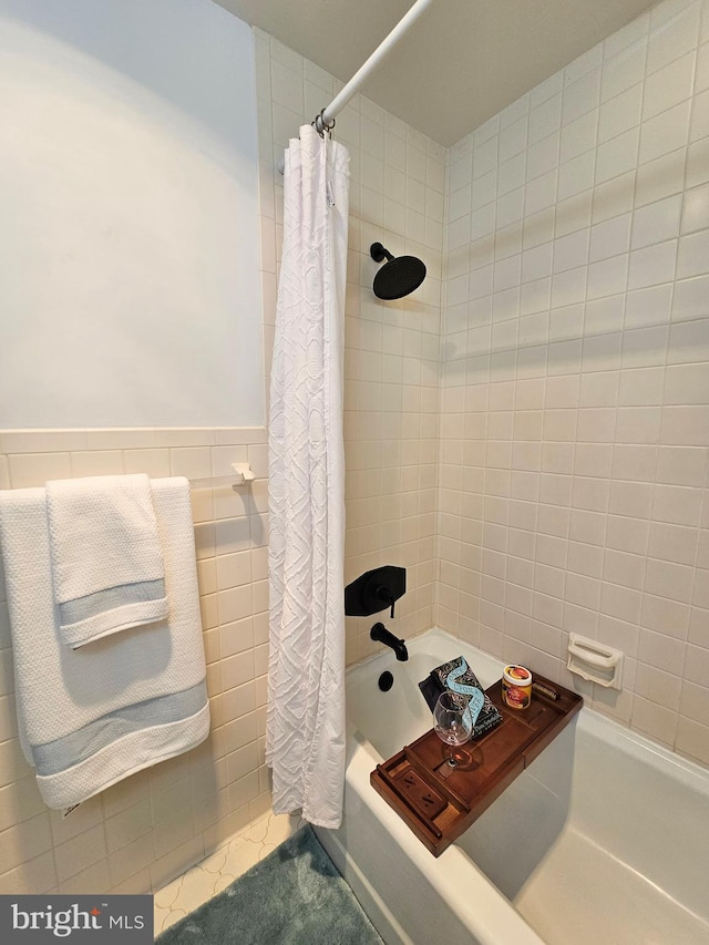 bathroom featuring tile walls and shower / bath combo