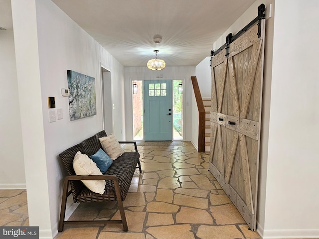 entryway featuring a barn door and light tile floors