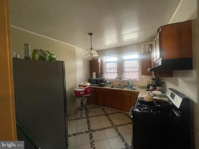 kitchen featuring light tile floors, decorative light fixtures, black appliances, and sink