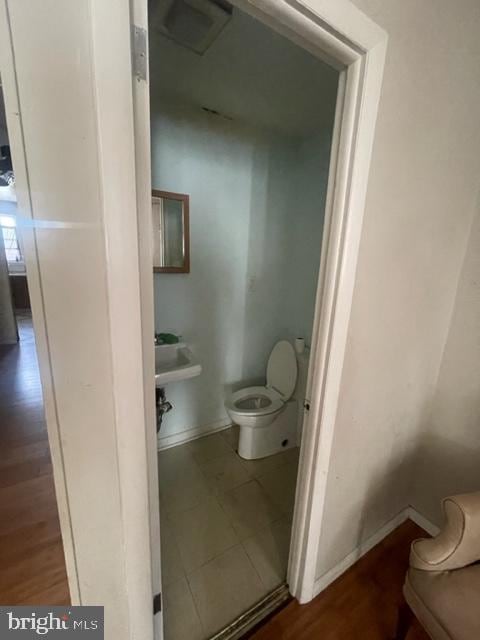 bathroom with toilet and tile floors