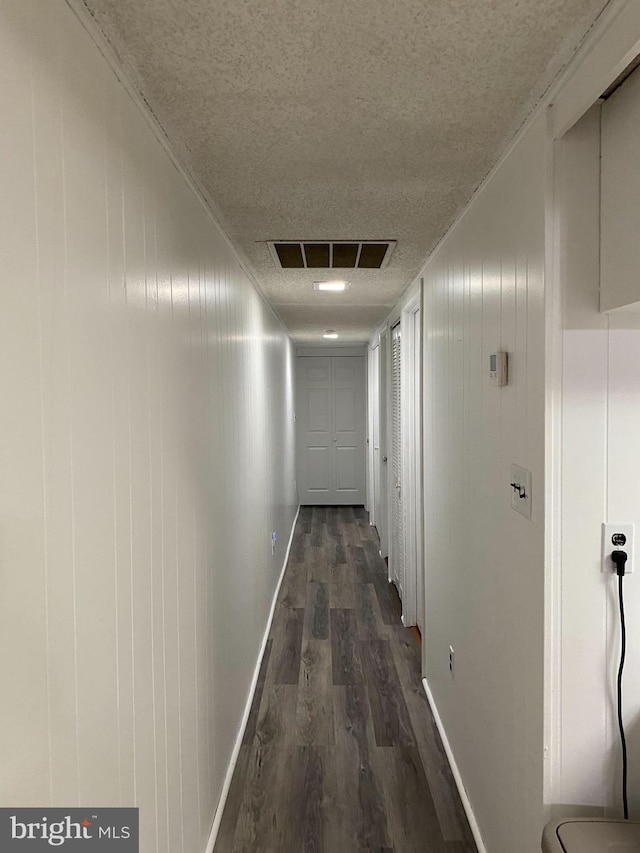 hall featuring dark hardwood / wood-style flooring and a textured ceiling