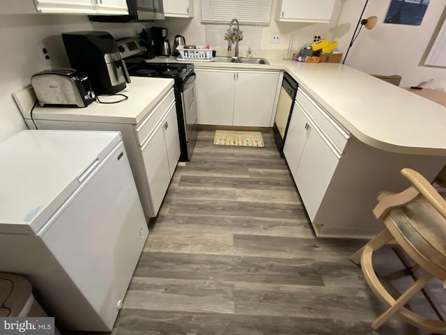 interior space with sink, white appliances, white cabinetry, wood-type flooring, and kitchen peninsula