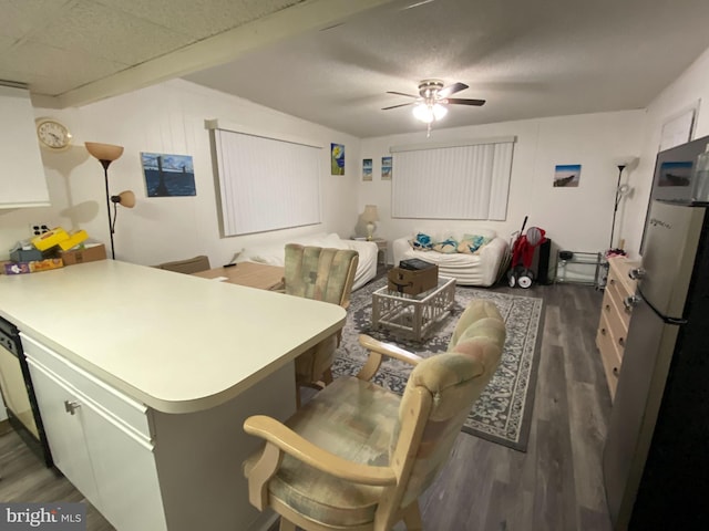 kitchen featuring dark hardwood / wood-style floors, ceiling fan, kitchen peninsula, and stainless steel fridge