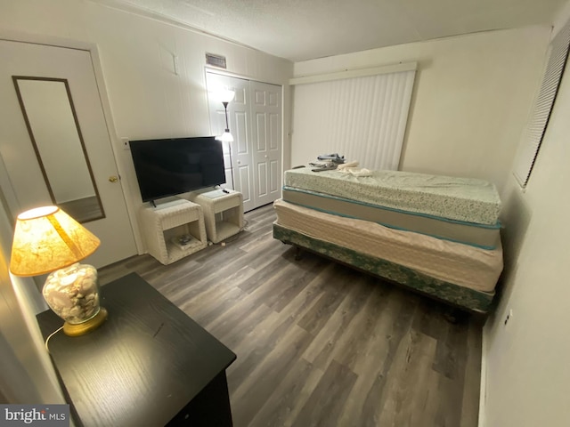 bedroom with a closet and dark wood-type flooring