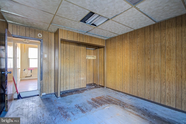 unfurnished room with dark hardwood / wood-style floors and wood walls