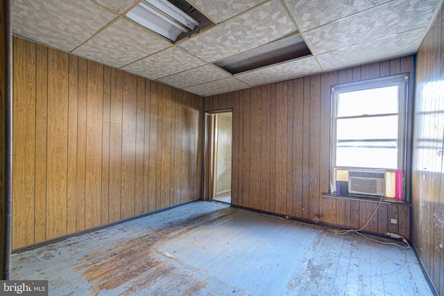 spare room with wood walls and a drop ceiling