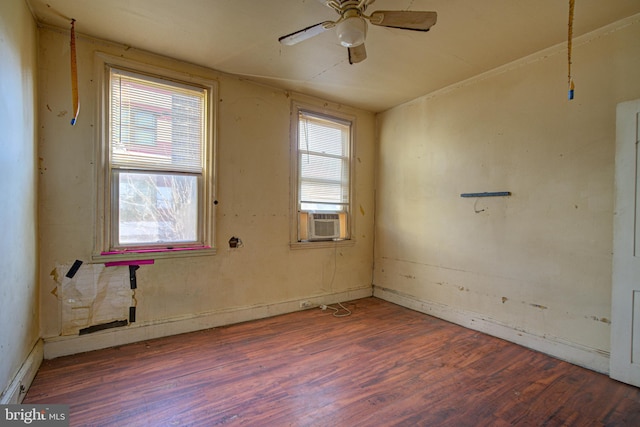 empty room featuring plenty of natural light, ceiling fan, and dark wood-type flooring