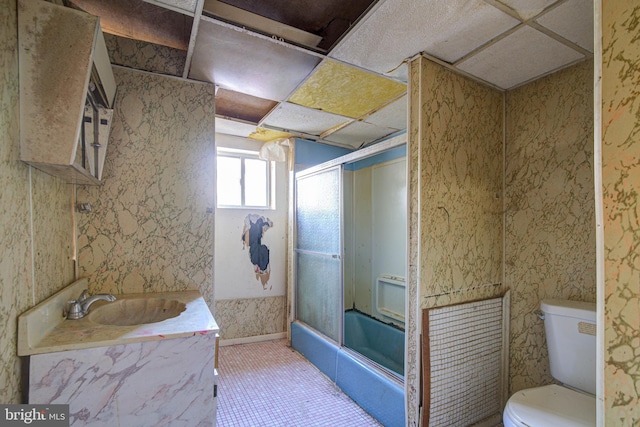 bathroom with toilet, tile floors, sink, and a paneled ceiling