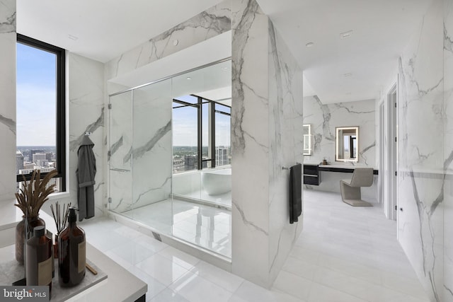 bathroom featuring expansive windows, separate shower and tub, and vanity