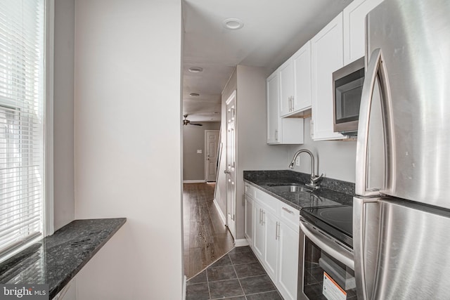 kitchen with white cabinetry, ceiling fan, sink, stainless steel appliances, and dark hardwood / wood-style flooring