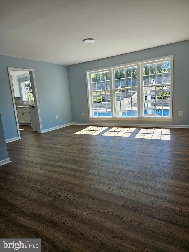 spare room featuring plenty of natural light and dark wood-type flooring