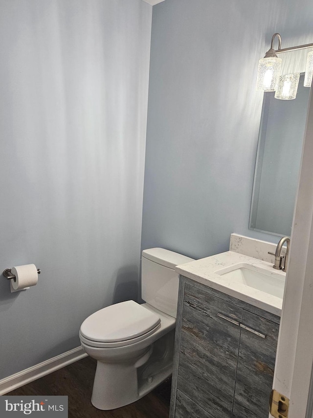 bathroom featuring hardwood / wood-style flooring, toilet, and vanity