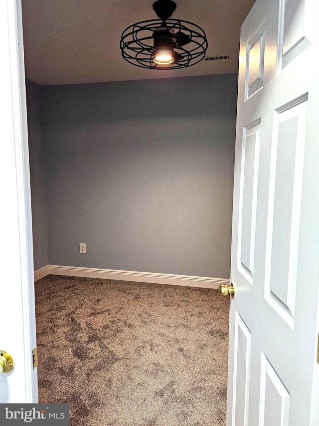 spare room with ceiling fan and carpet