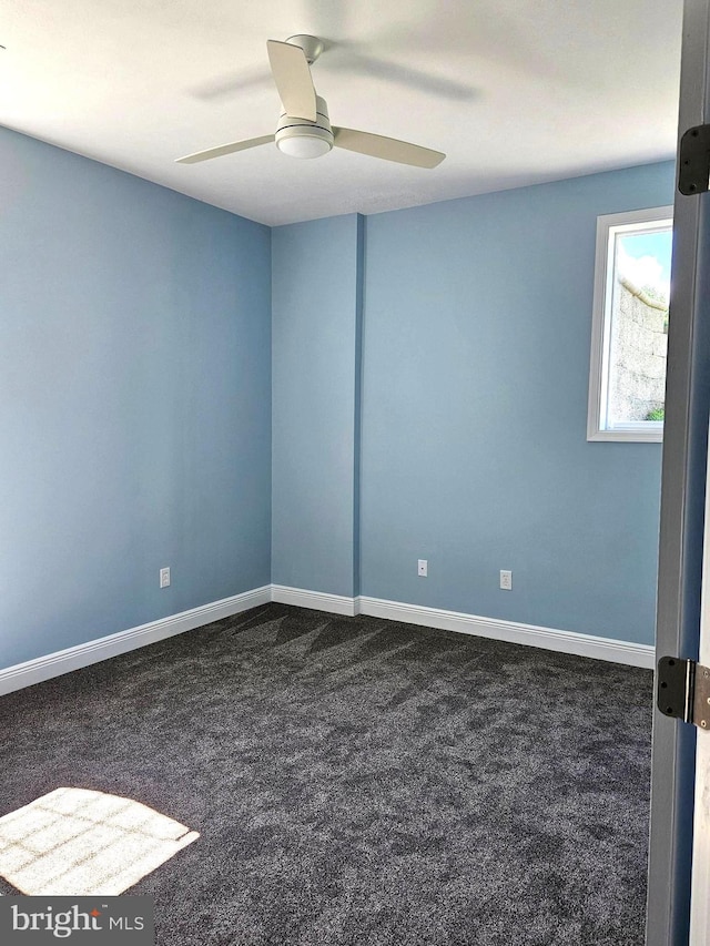 carpeted spare room with ceiling fan