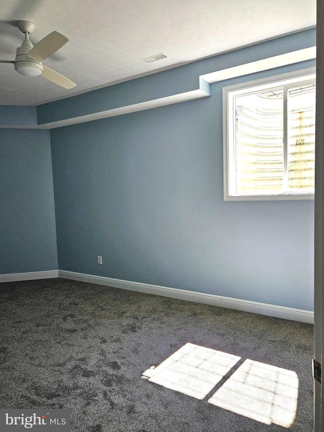 carpeted spare room featuring ceiling fan