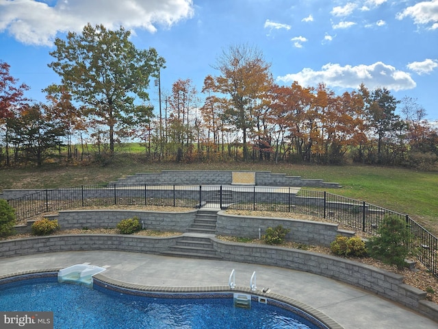 view of pool featuring a lawn