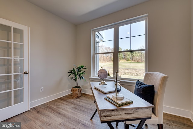 office featuring french doors, a wealth of natural light, and light hardwood / wood-style floors