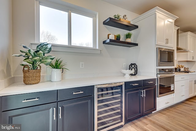 kitchen featuring white cabinetry, wine cooler, appliances with stainless steel finishes, and light hardwood / wood-style floors