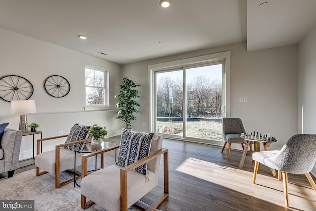 living area with a wealth of natural light and light hardwood / wood-style floors