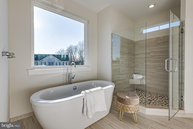 bathroom featuring shower with separate bathtub and tile floors