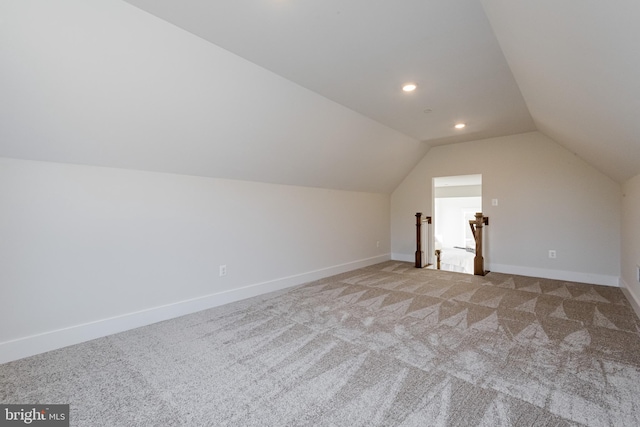 additional living space featuring lofted ceiling and light colored carpet