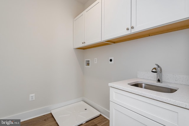 laundry area with light hardwood / wood-style floors, sink, hookup for a washing machine, electric dryer hookup, and cabinets