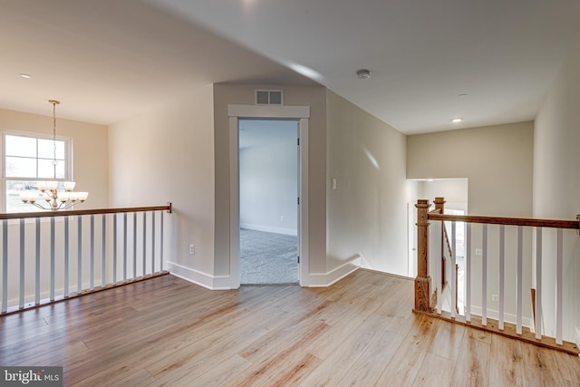 interior space featuring an inviting chandelier and light hardwood / wood-style flooring