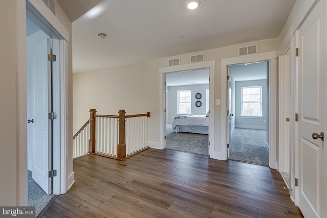 hall with dark colored carpet